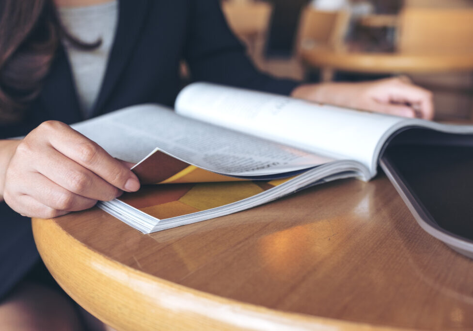 Closeup image of a business woman reading a book in modern cafe